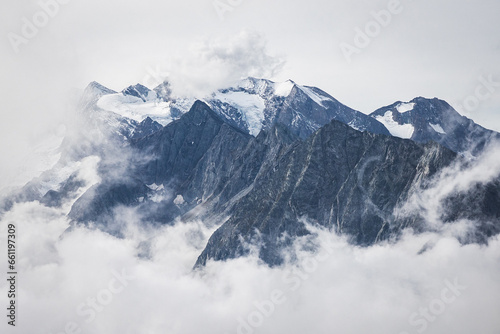 snow covered mountains looking through the fog and clouds  © Martin Moutayrek ©