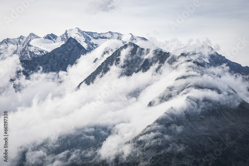 snow covered mountains looking through the fog and clouds  © Martin Moutayrek ©