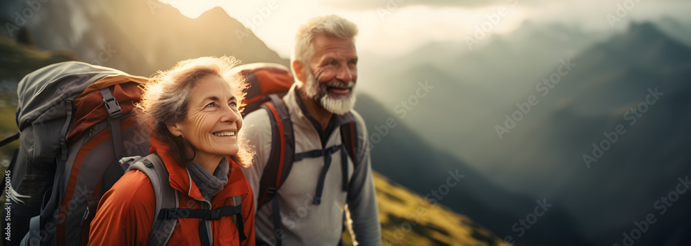 Obraz premium elderly couple climbing a mountain reaching the top - concept - age does not matter