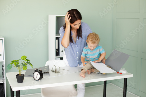 tired woman with a child. woman with child in office