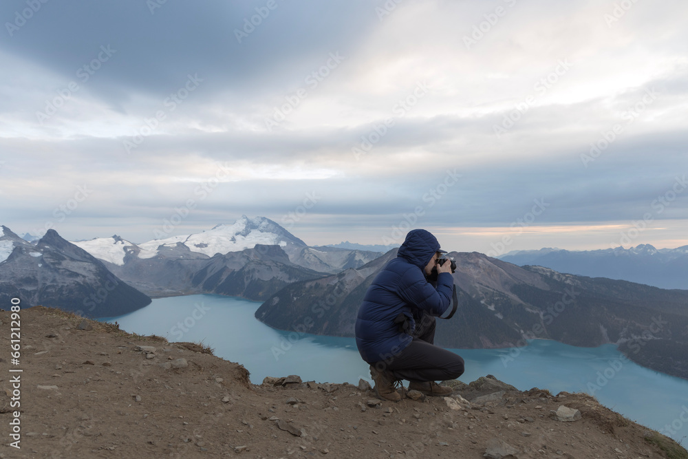 photographer taking photo of mountain and lake