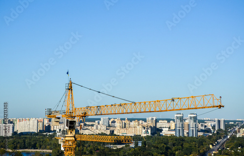 Tower crane on the background of Dnipro river and left bank of Kyiv city. New buildings architecture and industry construction