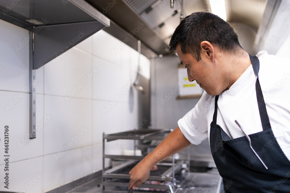 Latin adult man working in a restaurant kitchen Latin adult man working in a restaurant kitchen