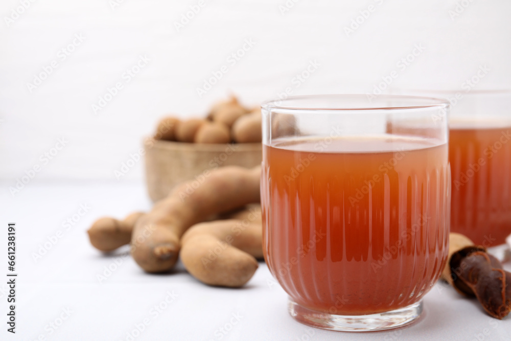 Tamarind juice and fresh fruits on white table, closeup. Space for text Tamarind juice and fresh fruits on white table, closeup. Space for text
