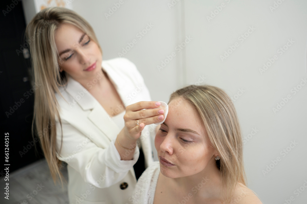 young female make-up artist working in the studio with model young female make-up artist working in the studio with model