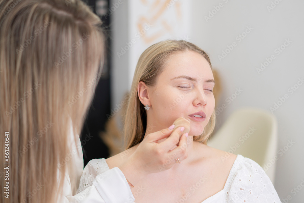 makeup artist holding a foundation sponge, choosing a right color makeup artist holding a foundation sponge, choosing a right color