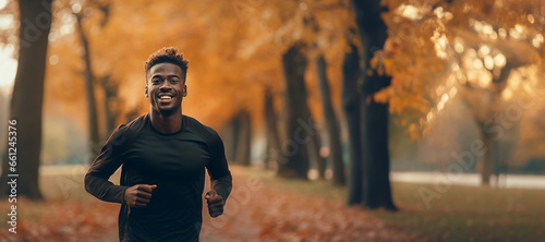 Young african american man running in the autumn park for health in the morning. Exercise and health, running and fitness with a man outdoor for cardio or endurance training.