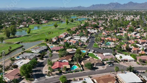 Country club retirement housing development and neighborhood in Scottsdale, Arizona. Southwest USA. Aerial orbit shot above houses and homes with golf course in background. photo