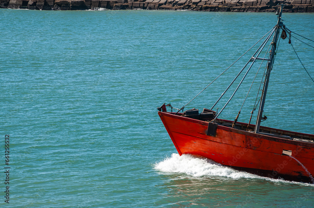 Naklejka premium Bow of a Trawler fishing vessel, raising sea foam as it sails, leaving the Port of Mar del Plata, Argentina.