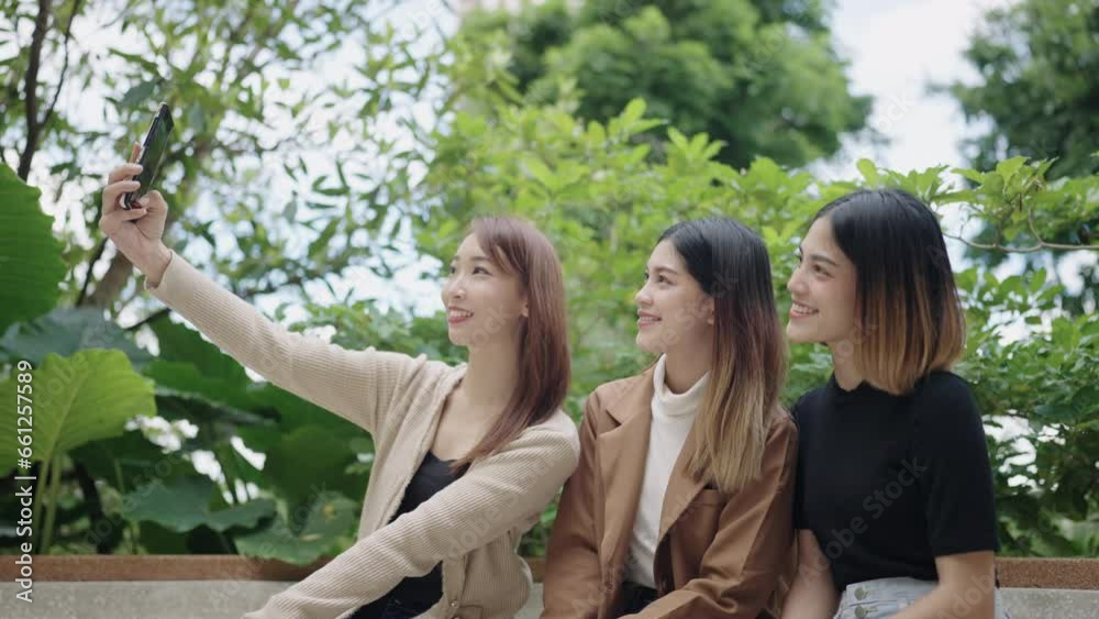 Group of Asian female students taking selfies on smartphones at university Group of Asian female students taking selfies on smartphones at university