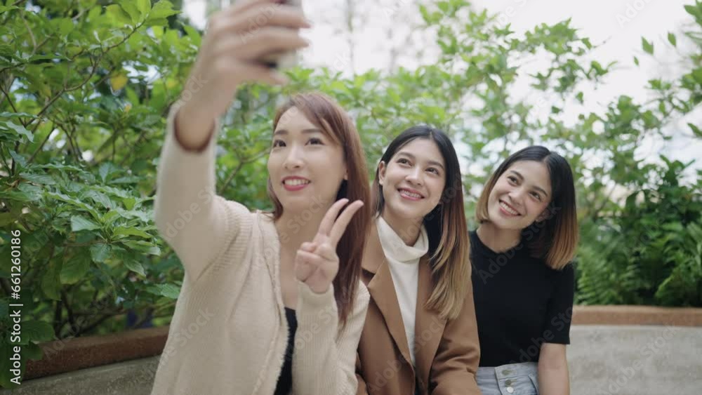 Group of Asian female students taking selfies on smartphones at university Group of Asian female students taking selfies on smartphones at university
