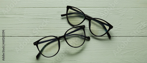 Stylish eyeglasses on green wooden background