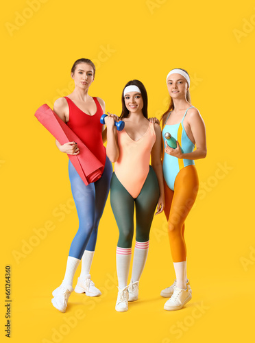 Portrait of sporty young women on yellow background