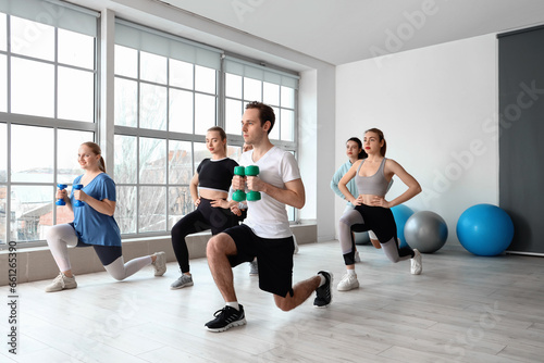 Group of sporty young people training in gym