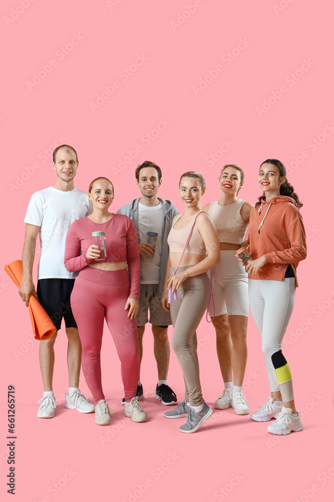 Obraz premium Group of sporty young people with equipment on pink background