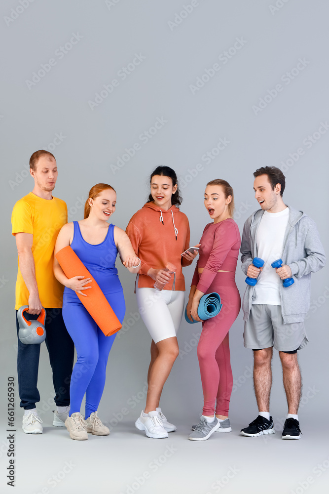 Fototapeta premium Group of sporty young people with equipment on grey background