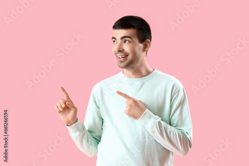 Young man pointing at somet...