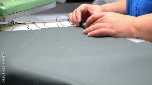 Employee cuts artificial leather with press machine