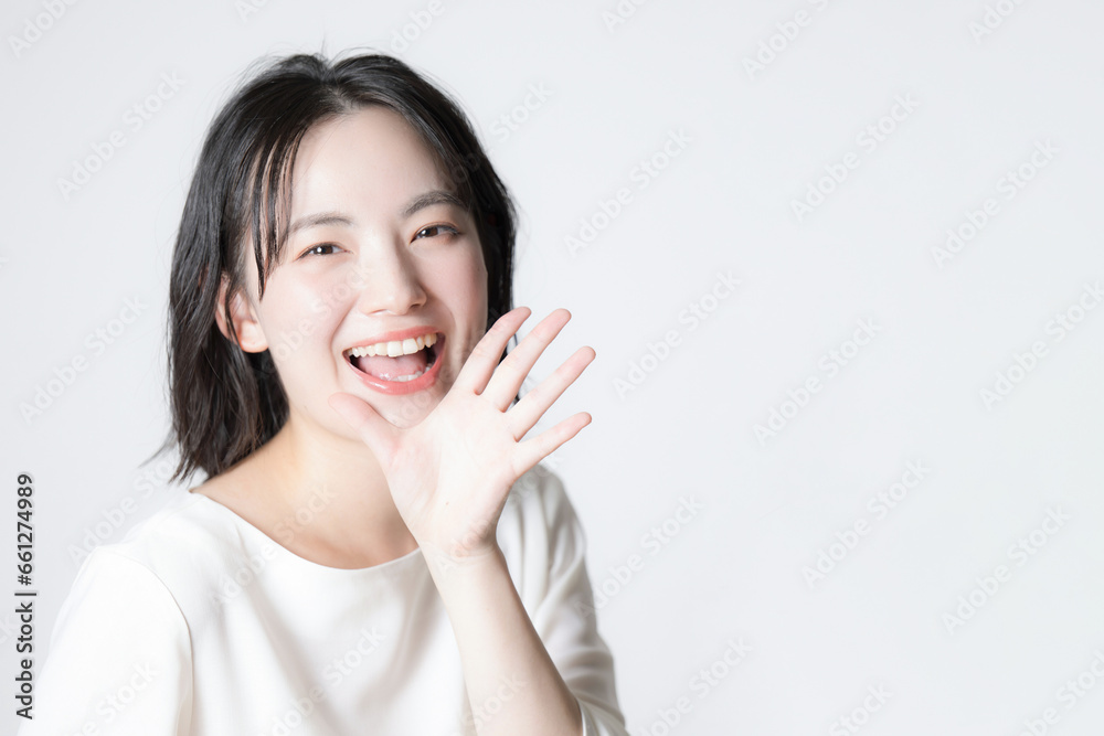 Close-up of young Asian (Japanese) woman smiling and calling Pose cheering and calling Close-up of young Asian (Japanese) woman smiling and calling Pose cheering and calling
