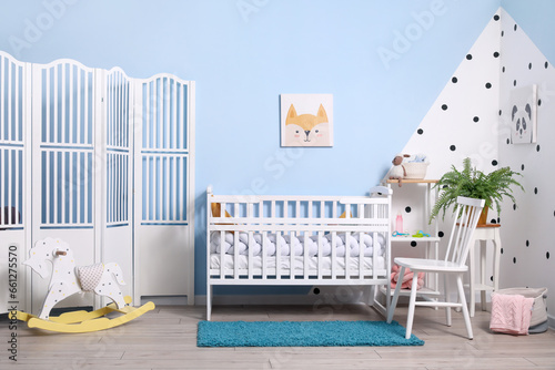 Interior of stylish children's bedroom with crib and pictures