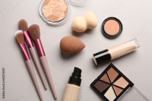 Set of makeup accessories and cosmetics on grey background
