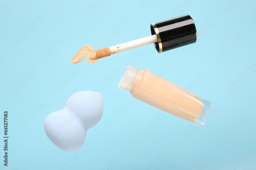 Makeup sponge and liquid foundation flying on color background Makeup sponge and liquid foundation flying on color background