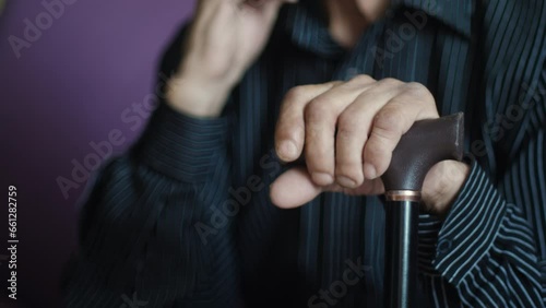 Closeup, senior and hands of man with cane for support, walking help and aging. Morning, house and elderly person with gear for a walk on the living room sofa for healthcare and holding for strength. photo