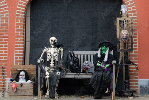 Halloween decoration, holiday, decorating houses, house ready for halloween holiday, tradition,A skeleton and a witch are sitting on a bench
