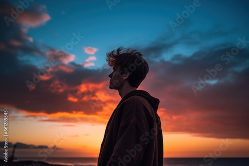 Young man looking at sky at sunset