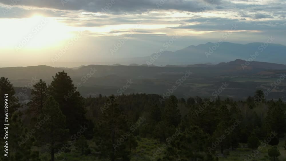 Aerial view backwards low over highland forest, cloudy sunset in Utah, USA Aerial view backwards low over highland forest, cloudy sunset in Utah, USA