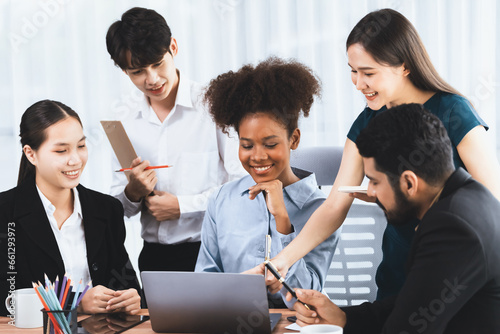 Happy diverse business people work together  discussing in corporate office. Professional and diversity teamwork discuss business plan on desk with laptop. Modern multicultural office worker. Concord
