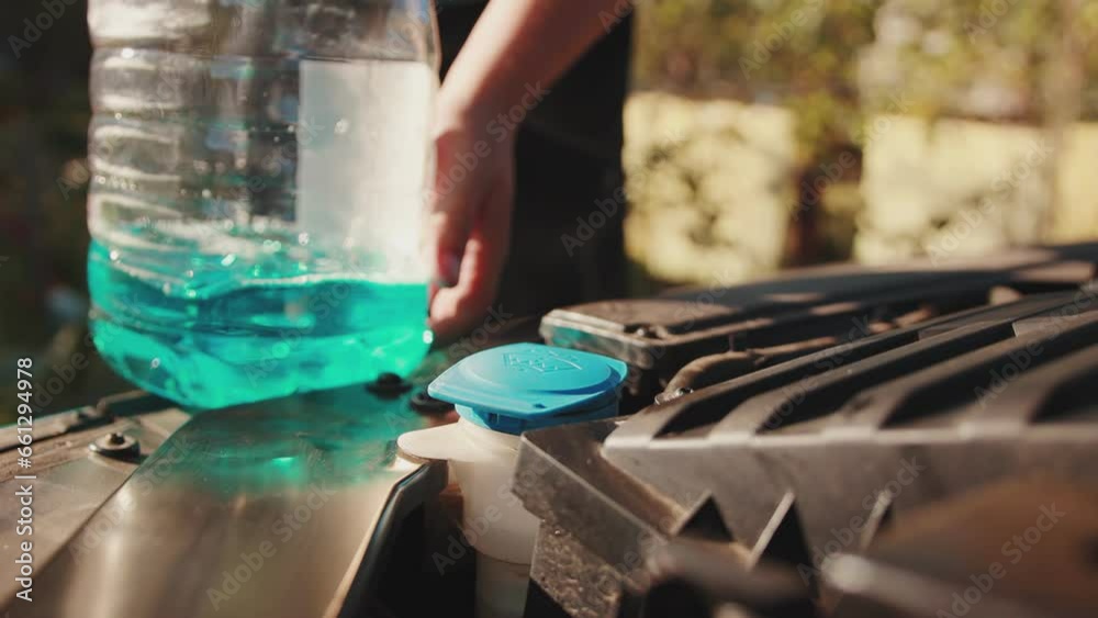 A man brings antifreeze windshield washer fluid to be poured into the