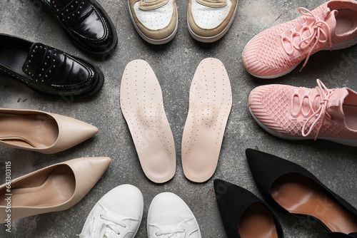 Composition with different female shoes and orthopedic insoles on grunge background