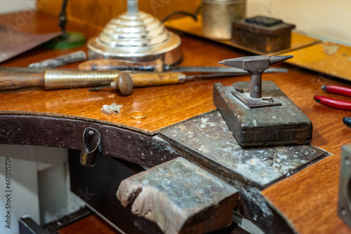 Craft workplace of a jeweler. Jewelry tools and equipment on a goldsmith wooden desk table.