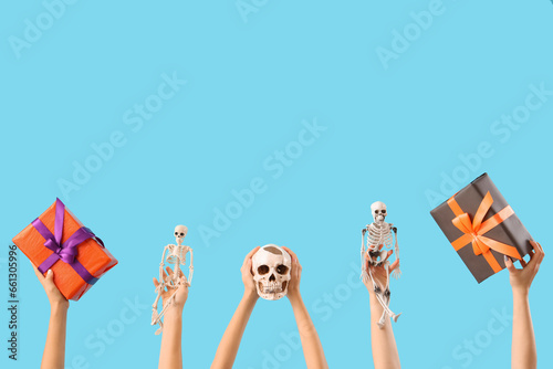 Women with Halloween gifts and skeletons on blue background