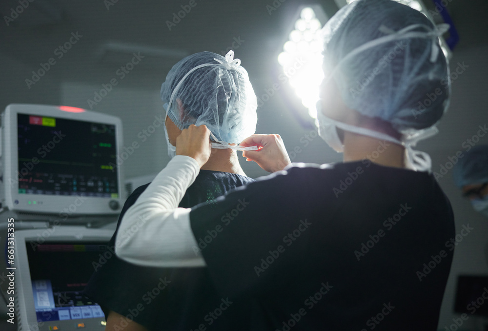 Getting ready, healthcare and doctors in a surgery theater for medical procedure or treatment. Help, clothing and surgeons with hair nets at a hospital for a clean operation or teamwork in medicine - obrazy, fototapety, plakaty 