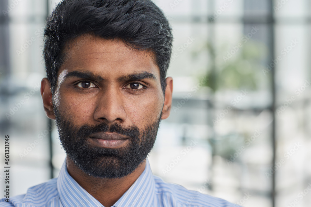 Close up portrait of young attractive serious guy in blue shirt looking straight in the camera Close up portrait of young attractive serious guy in blue shirt looking straight in the camera
