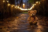 bear toy on a park path illuminated by string lights