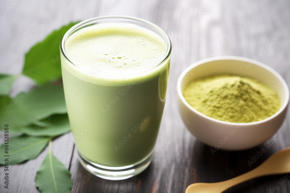 matcha latte in the foreground, matcha tea leaves in the background matcha latte in the foreground, matcha tea leaves in the background