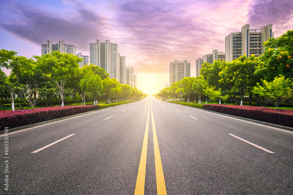 Empty asphalt road and city buildings in Hangzhou at sunset