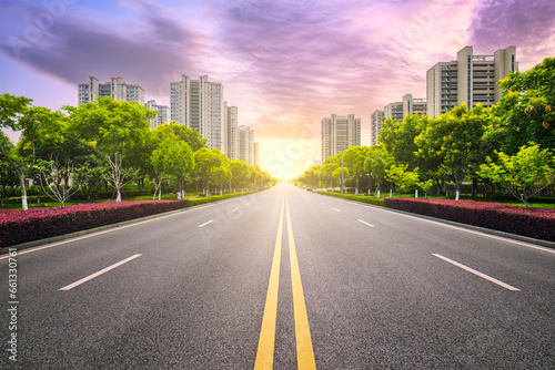 Empty asphalt road and city buildings in Hangzhou at sunset