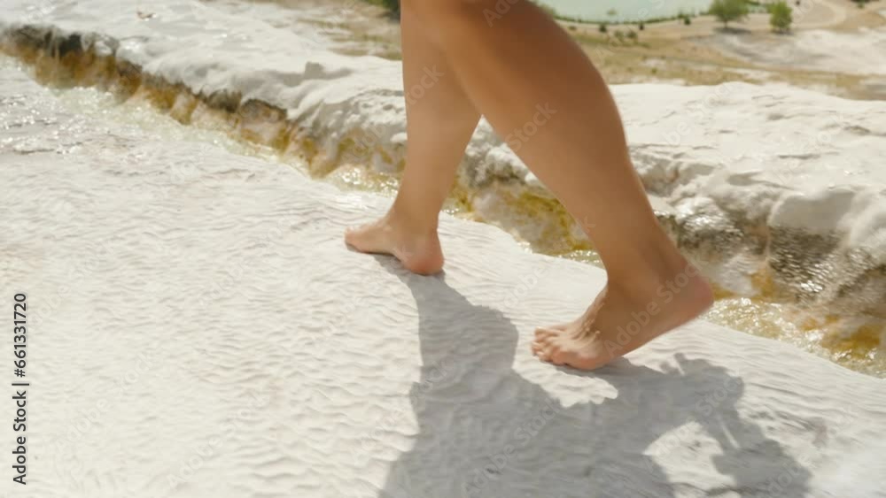 Ancient Formations in Pamukkale. White Travertines where a barefoot woman strolls, water carving its path within the rock. Ancient Formations in Pamukkale. White Travertines where a barefoot woman strolls, water carving its path within the rock.