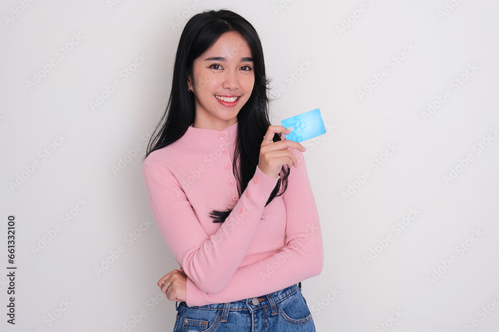 Asian young women smiling confident while holding blank credit card Asian young women smiling confident while holding blank credit card