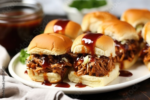 bbq pork sliders with spicy bbq sauce drizzled on top on a round plate