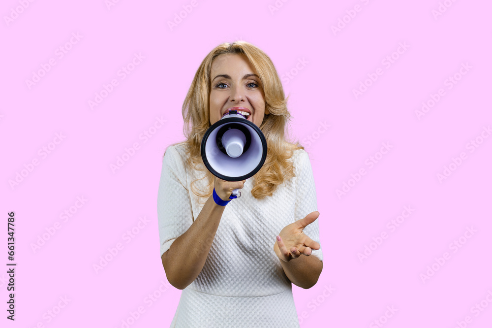 Happy positive blonde woman giving a speech in megaphone. Isolated on pink. Happy positive blonde woman giving a speech in megaphone. Isolated on pink.