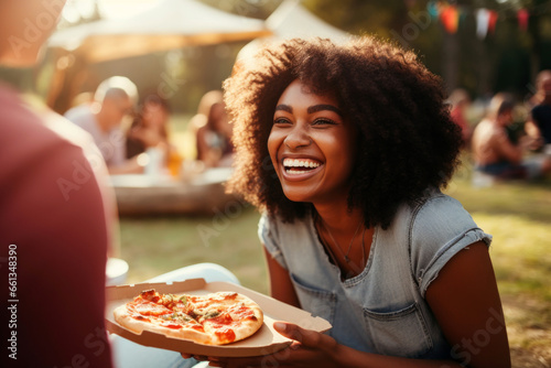 happy woman holding pizza in park picnic