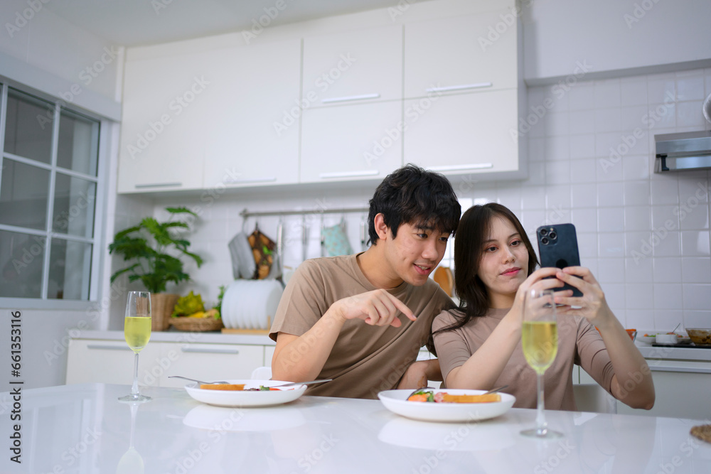 Young couple is shopping online in kitchen.