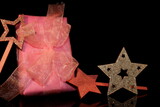 A beautiful pink gift with a bow and stars, on a black background