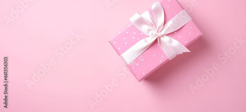 Gender reveal party concept, Top view photo of pink giftbox with white ribbon bow on isolated pastel pink background with copyspace © alisaaa