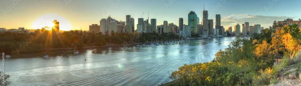 Fototapeta premium Panoramic view of a modern cityscape near a river at golden hour